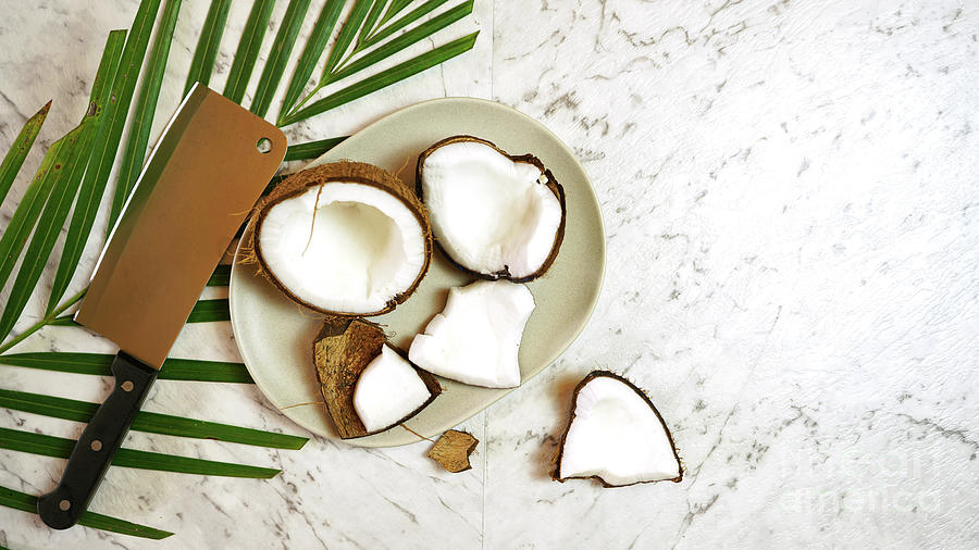 1-coconut-cut-into-pieces-on-plate-on-marble-table-top-creative-flat-lay-milleflore-images